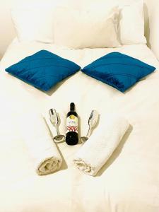 a bed with two blue pillows and a bottle of alcohol at נופי ארבל in Livnim