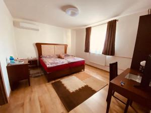 Schlafzimmer mit einem Bett, einem Tisch und einem Fenster in der Unterkunft Penzión Tyché in Šurany