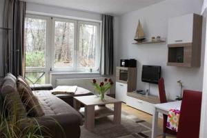 ein Wohnzimmer mit einer Couch, einem Tisch und einem Fernseher in der Unterkunft Zinnowitz Haus Zur Düne in Zinnowitz