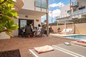 a woman sitting at a table next to a house at Casa de Marina in San Miguel de Abona