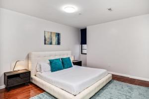 a bedroom with a white bed with blue pillows at Cozy and stylish 2BD Apt with great location! in Philadelphia