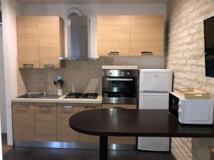 una cucina con tavolo, piano cottura e frigorifero di Bellagio sweet home a Firenze
