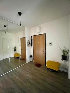 una habitación vacía con puerta de cristal y reposapiés amarillo en Konstruktorska Chill, en Varsovia