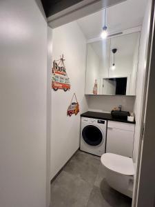 a bathroom with a toilet and a washing machine at Konstruktorska Chill in Warsaw