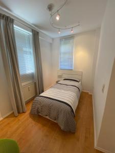 a bed in a room with two windows at Ferienwohnung Bad Laasphe Altstadt in Bad Laasphe