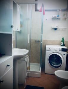 a bathroom with a washing machine and a washer at Casa EleGiò - Blue Village 2 in Marina di Pisticci