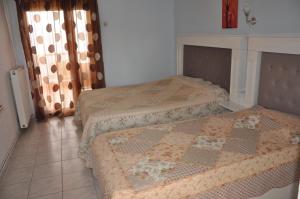 a bedroom with two beds and a tiled floor at Drenos Rooms view in Kallithea Halkidikis
