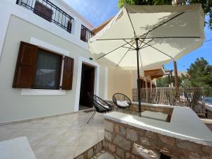 un patio con mesa y sombrilla en Celestia Apartments, en Halki