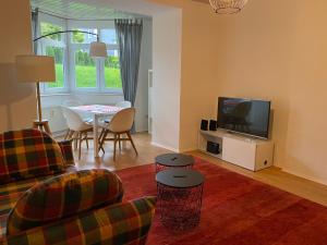 a living room with a couch and a tv and a table at Ferienwohnung Bad Laasphe Altstadt in Bad Laasphe