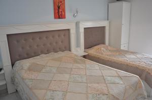 1 dormitorio con 2 camas y reloj rojo en la pared en Drenos Rooms view, en Kallithea Halkidikis