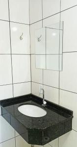 un bagno con lavandino e specchio di HOTEL SAYMON a Cafelândia