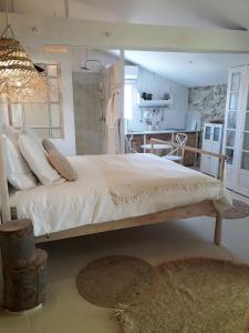 uma cama grande num quarto com uma cozinha em Le Sens des Merveilles em Mane
