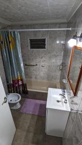 uma casa de banho com um lavatório, uma banheira e um WC. em Apart termas em Termas de Río Hondo
