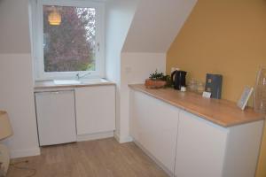 a kitchen with a sink and a window at Les chambres du Vert Galant "Coucher de soleil" in Verlinghem