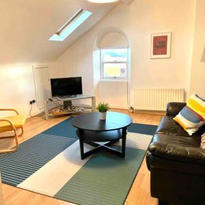 a living room with a couch and a coffee table at Flat 7 EIA House in Belfast