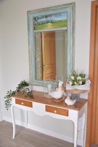 um toucador com espelho e flores em Les chambres du Vert Galant "Coucher de soleil" em Verlinghem