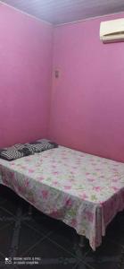 um quarto com uma cama numa parede cor-de-rosa em Casa Cantinho de Santarém em Santarém