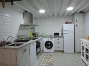 a kitchen with a white refrigerator and a dishwasher at Picaza del Jerte in Cabezuela del Valle