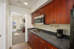 a kitchen with wooden cabinets and a microwave at Monte Carlo Condos Ocean City in Ocean City