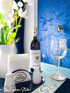 een fles wijn zittend op een tafel met een glas bij Blu Euphoria Studio in Mamaia Nord – Năvodari
