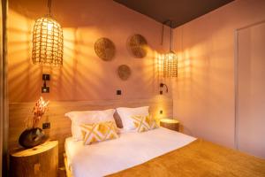 a bedroom with a bed with two pillows and two lights at Paradisio Baby & Kinder Hotel in Stavros