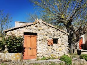 una pequeña casa de piedra con puerta de madera en Mas La belle Ambroise - Chambres d'hôtes et Gîte, en Saint-Ambroix