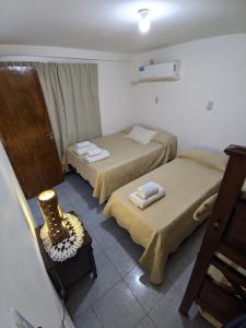 a room with two beds and a chair in it at Apart termas in Termas de Río Hondo