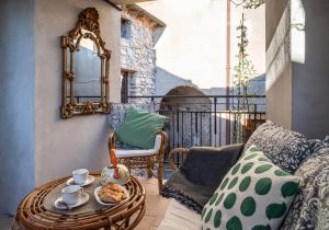 einen Balkon mit einem Tisch, einem Spiegel und einem Stuhl in der Unterkunft B&B Porta Soprana in Trentinara