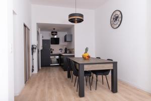 cocina y comedor con mesa negra y sillas en Appartement 70m2 hyper centre avec baignoire balnéo, en La Flèche
