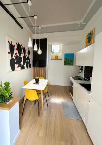 a kitchen and dining room with a white table and yellow chairs at ERASMO 19 Luxury Home in Catania +29 photos