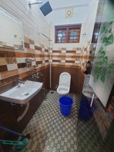 een badkamer met een wastafel en een toilet bij MG TOWER Hotel in Trivandrum