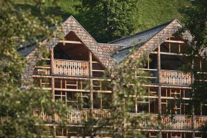 Casa de madera con techo y porche en Tenne Lodges en Racines