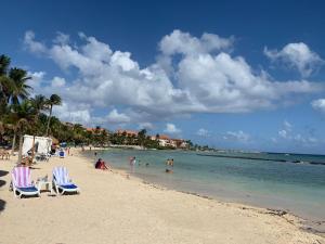 a beach with chairs and people in the water at Villa Camilla in Puerto Aventuras