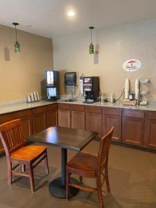 eine Küche mit einem Tisch, 2 Stühlen und einer Theke in der Unterkunft Super 8 by Wyndham Altoona in Altoona