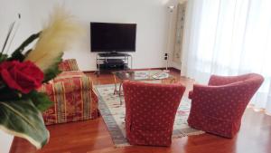 salon z 2 krzesłami, stołem i telewizorem w obiekcie Diamante: Appartamento nel cuore della Toscana w mieście Castelfranco di Sotto