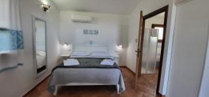 a bedroom with a bed in a white room at Agriturismo Su Barcu in Cala Gonone