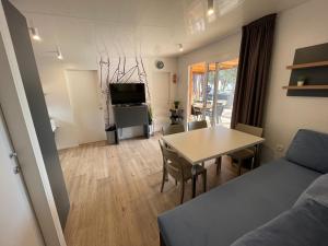 - un salon avec une table et un canapé dans l'établissement Mobile Home BARTOL de LUX, à Biograd na Moru