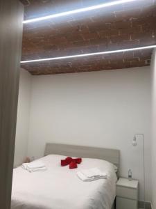 uma cama com um laço vermelho em cima em Elegante e spazioso bilocale in zona Certosa (FI) em Florença