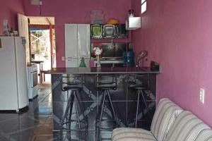 eine Küche mit einer Bar mit einem Sofa in einem Zimmer in der Unterkunft Casa Cantinho de Santarém in Santarém