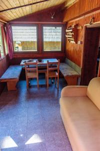 uma sala de jantar com mesa, bancos e janelas em Holiday house Pokljuka - Bohinj em Koprivnik v Bohinju