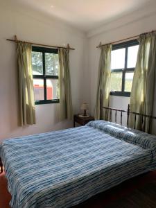 a bedroom with a bed and two windows at Tranquilo entorno campestre in Treinta y Tres