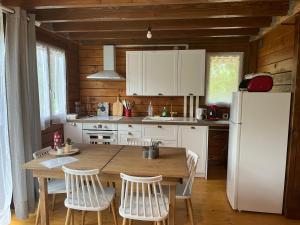 cocina con mesa de madera y nevera blanca en Chalet du Trèfle, en Chalais