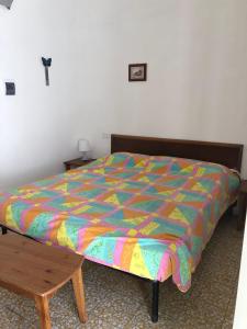 un letto con un piumone colorato in una camera da letto di Rocca Sul Mare Hotel a Vieste