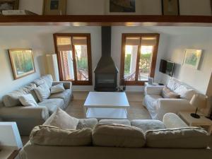 Una sala de estar con sofás blancos y una chimenea. en Can Botana 3, en Cala de Sant Vicent