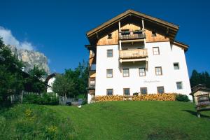 ein großes weißes Gebäude mit einem Holzdach in der Unterkunft Appartamenti Sotgherdena in Abtei