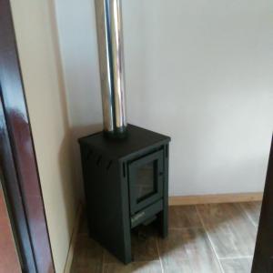 a black stove in the corner of a room at Palmares al cerro in Capilla del Monte