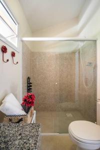 uma casa de banho com um chuveiro, um WC e um lavatório. em BANGALOS FLORIANÓPOLIS em Florianópolis