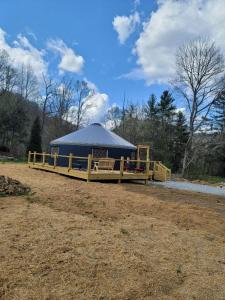 un kiosque avec une tente bleue dans un champ dans l'établissement Maggie Valley Cabin Rentals, à Maggie Valley