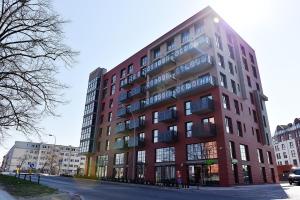 un grand bâtiment rouge sur le côté d'une rue dans l'établissement Apartamenty Gdansk EU - Dwie Motławy - OLD TOWN, à Gdańsk