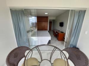 a living room with a bed and two chairs at Garvey Apart Hotel in Brasilia